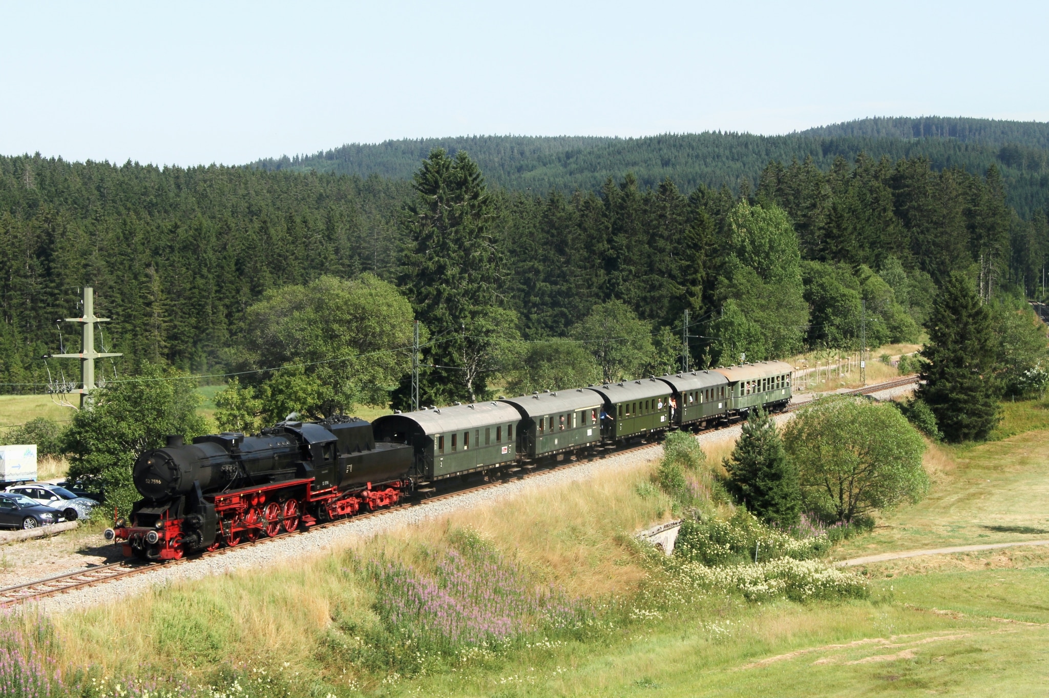 Die historische Dampflokomotive fährt durch die idyllische Schwarzwaldlandschaft am Schluchsee.