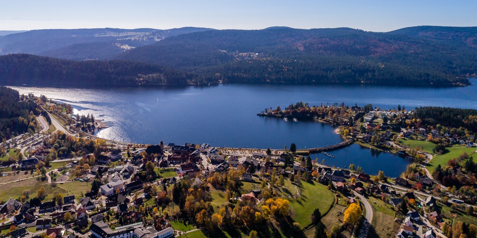 Panorama-Aufnahme des Schluchsees aus der Vogelperspektive bei klarem Wetter.