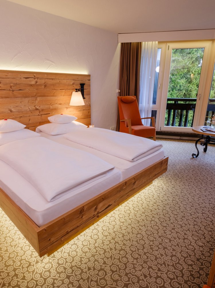 Helles Doppelzimmer Klassik Wald mit gemütlichem Doppelbett und Balkonzugang im Hotel Vier Jahreszeiten am Schluchsee.