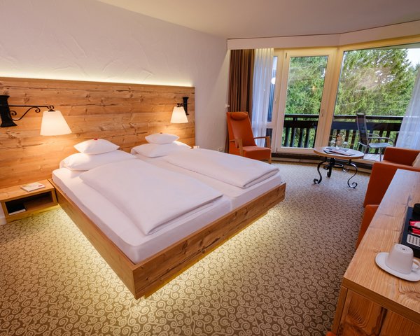 Helles Doppelzimmer Klassik Wald mit gemütlichem Doppelbett und Balkonzugang im Hotel Vier Jahreszeiten am Schluchsee.
