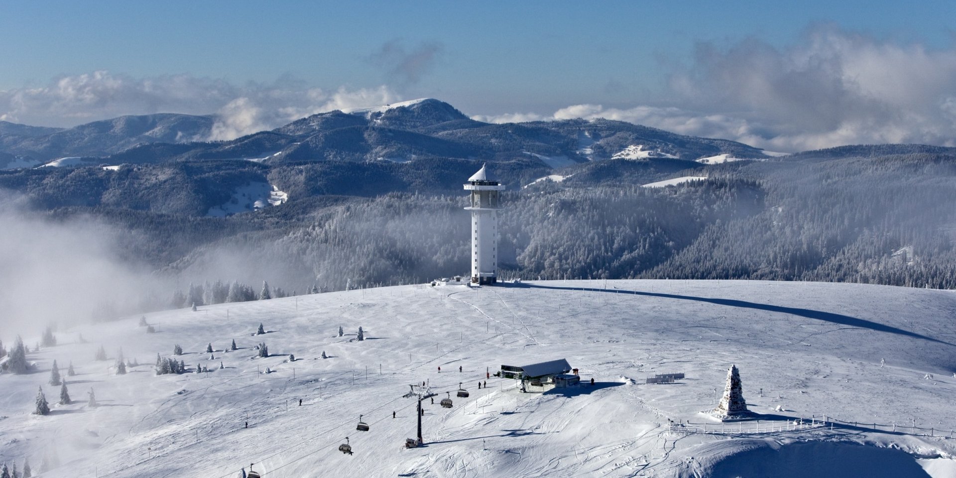 Luftaufnahme der verschneiten Liftanlagen und Pisten im Skigebiet Feldberg im Schwarzwald.