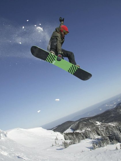 Ein Snowboarder springt während einer Abfahrt im Schwarzwald hoch in die Luft.