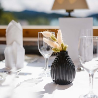 Detailaufnahme einer eleganten Tischdekoration mit weißen Lilien im Panorama-Restaurant des Hotels Vier Jahreszeiten am Schluchsee.