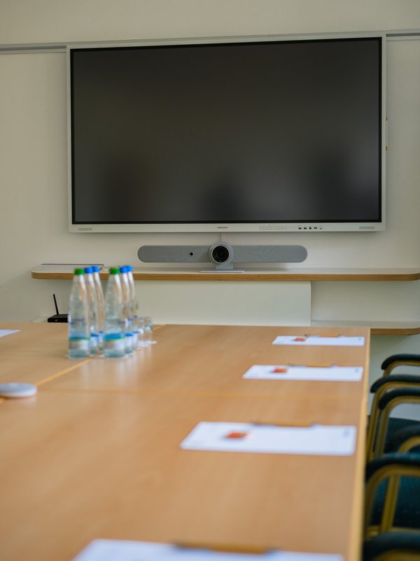 Detailansicht eines Besprechungstisches mit Unterlagen vor einem großen Präsentationsbildschirm im Hotel Vier Jahreszeiten am Schluchsee.