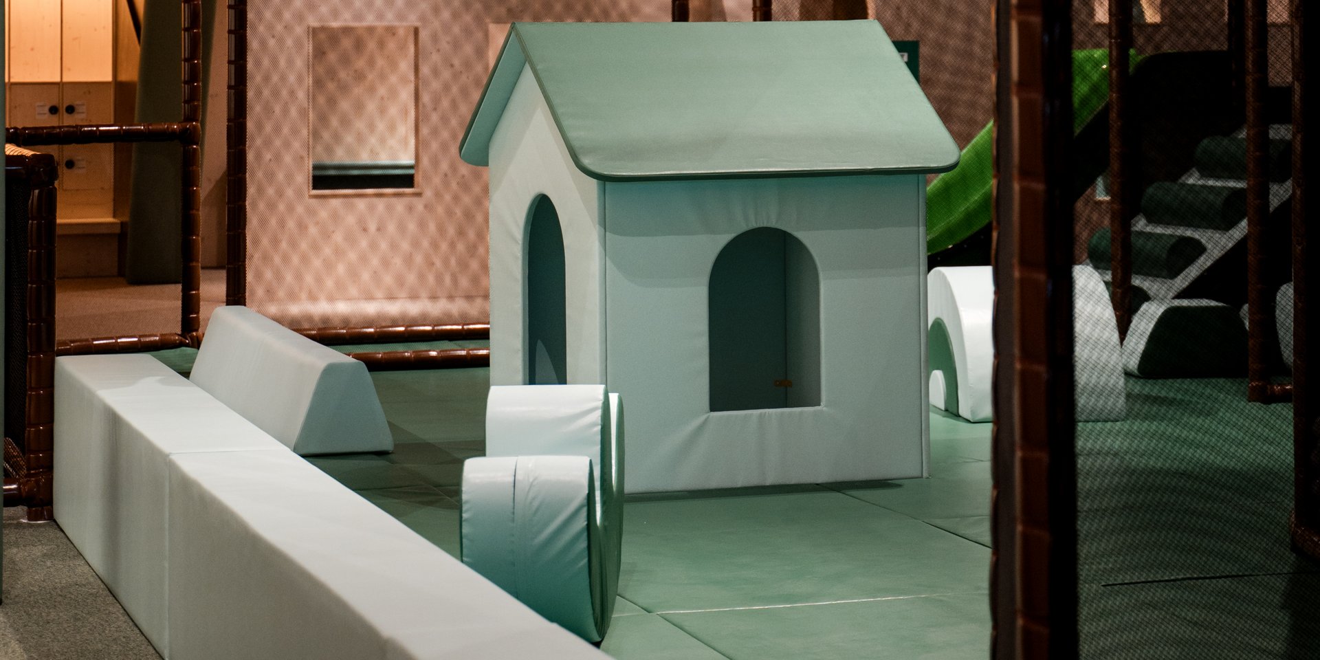 Ein kleines Spielhaus aus Holz inmitten der weitläufigen Indoor-Spiellandschaft des Hotels Vier Jahreszeiten am Schluchsee.