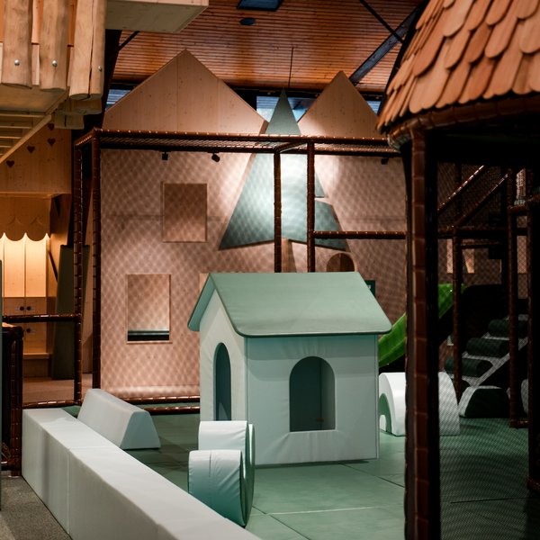 Ein kleines Spielhaus aus Holz inmitten der weitläufigen Indoor-Spiellandschaft des Hotels Vier Jahreszeiten am Schluchsee.