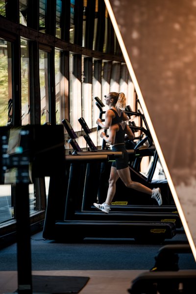 Gäste trainieren auf professionellen Laufbändern in der lichtdurchfluteten Sporthalle im Schwarzwald.