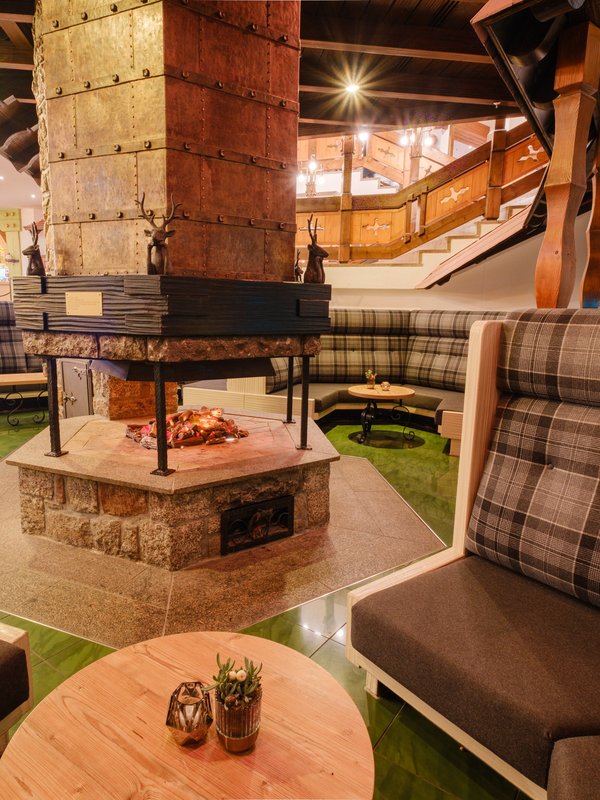 Rustikale Kaminecke mit gemütlichen Karo-Sitzbänken im Hotel Vier Jahreszeiten am Schluchsee.