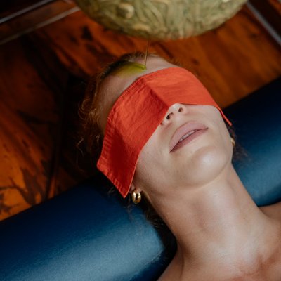 Ein Gast mit Augenmaske während eines entspannenden Ayurveda-Stirngusses im Hotel Vier Jahreszeiten.