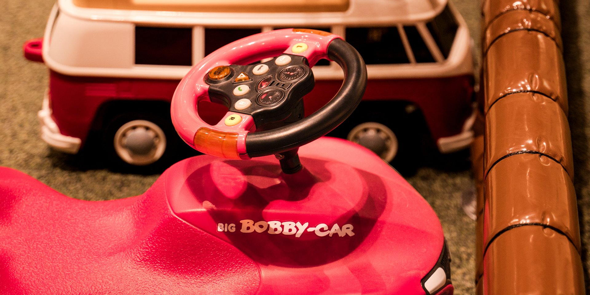 Eine Reihe bunter Spielzeugautos und kleiner Fahrzeuge steht für die kleinen Gäste im Hotel Vier Jahreszeiten bereit.