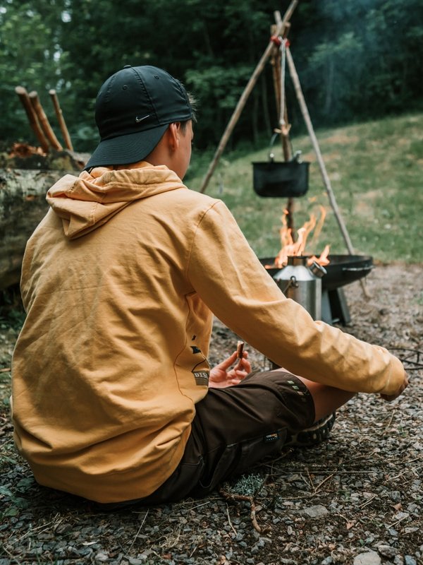 Ein Teilnehmer meditiert vor seinem Zelt in der ruhigen Natur beim Hotel Vier Jahreszeiten am Schluchsee.