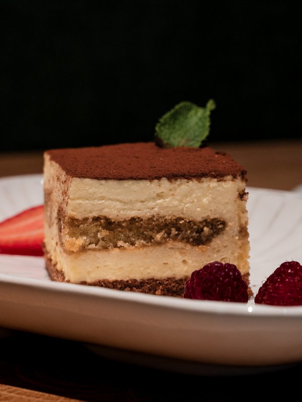 Ein klassisches Tiramisu mit frischen Beeren, kunstvoll angerichtet im Restaurant Lucia.