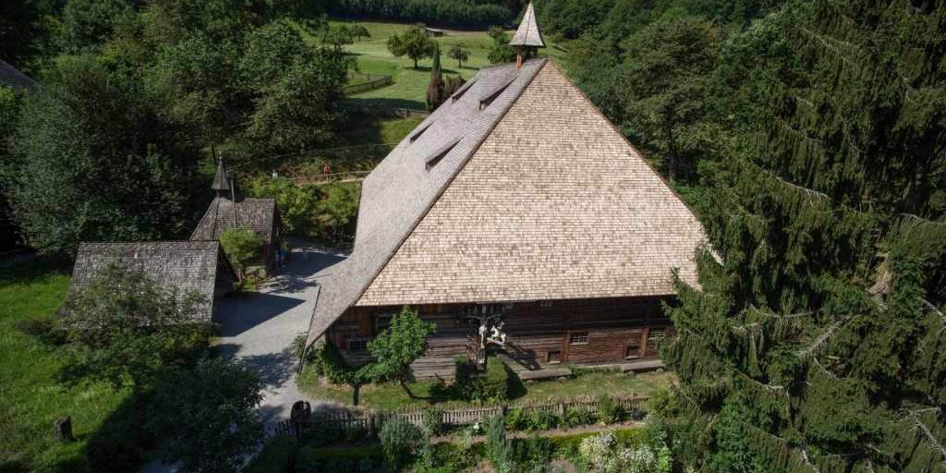 Historisches Bauernhaus mit Reetdach in einer ländlichen Parkanlage des Freilichtmuseums.
