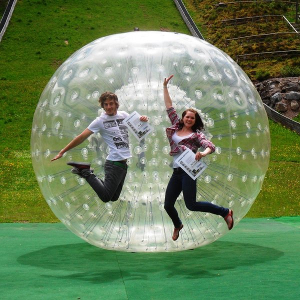 Actionreiches Winter-Event im Schwarzwald: Menschen in aufblasbaren Zorb-Bällen im Schnee.