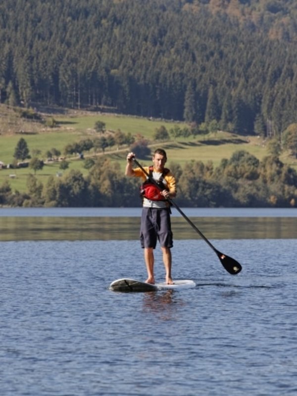Stand-up-Paddling auf dem Schluchsee im Schwarzwald mit Blick auf die idyllische Uferlandschaft.