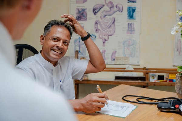 Ayurveda-Spezialist erklärt einem Gast die Behandlungsabläufe im Hotel Vier Jahreszeiten im Schwarzwald.
