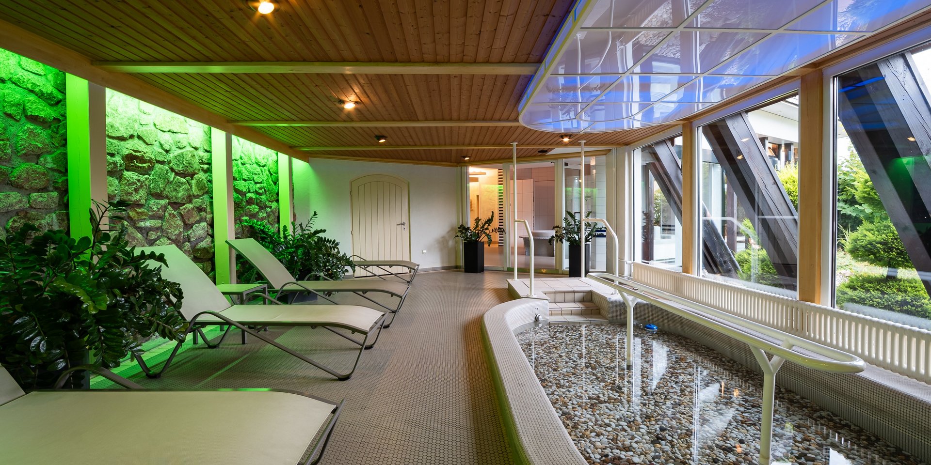 Moderner Ruheraum mit komfortablen Liegen und Blick ins Grüne im Hotel Vier Jahreszeiten am Schluchsee.