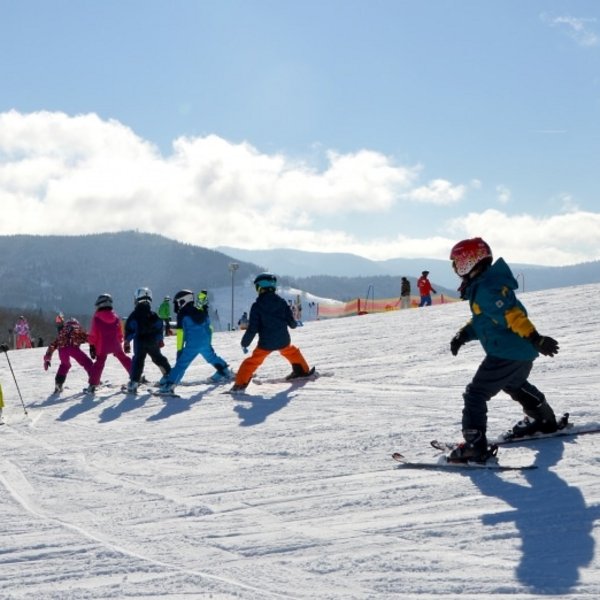 Skikurs für Kinder auf einer verschneiten Piste am Feldberg im Hochschwarzwald.