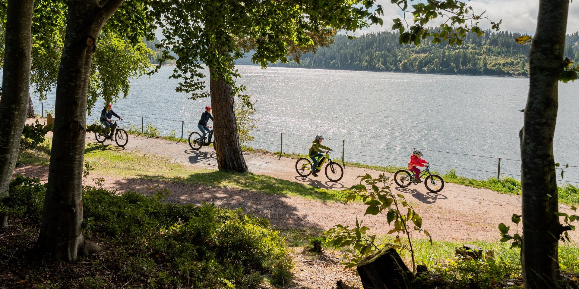 Radfahrer auf einem Uferweg am Schluchsee in der Nähe des Hotels Vier Jahreszeiten.