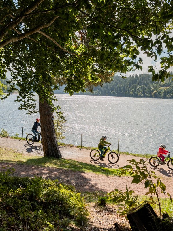 Radfahrer auf einem Uferweg am Schluchsee in der Nähe des Hotels Vier Jahreszeiten.