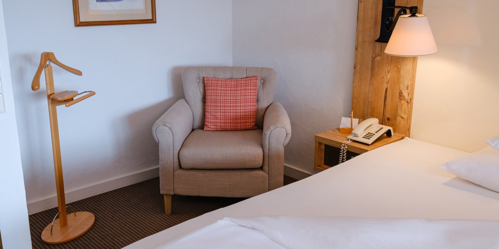 Helle Zimmerecke mit Einzelbett und Leselampe im Hotel Vier Jahreszeiten am Schluchsee.