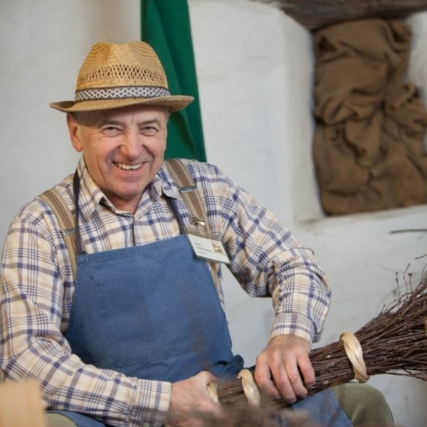 Traditionelles Schwarzwald-Handwerk: Ein Besenbinder bei der Arbeit in Tracht.