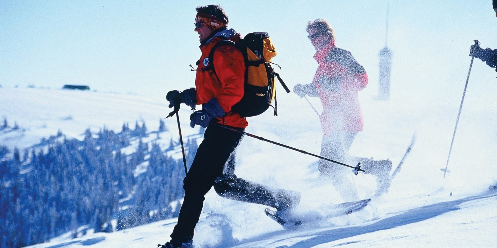 Wanderer bei einer geführten Schneeschuhtour durch die tief verschneite Gipfellandschaft des Feldbergs.