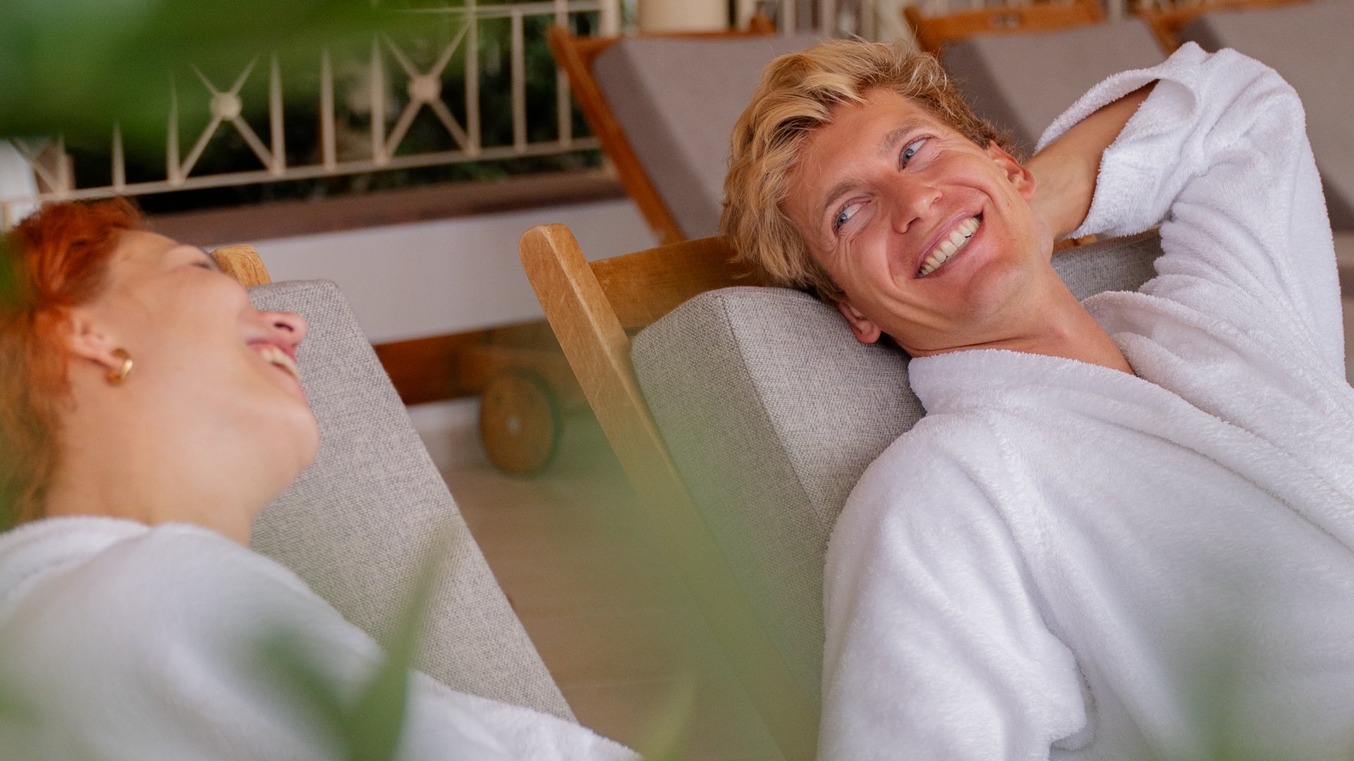 Zwei Gäste entspannen in flauschigen Bademänteln auf bequemen Liegen im Spa des Hotels Vier Jahreszeiten im Schwarzwald.