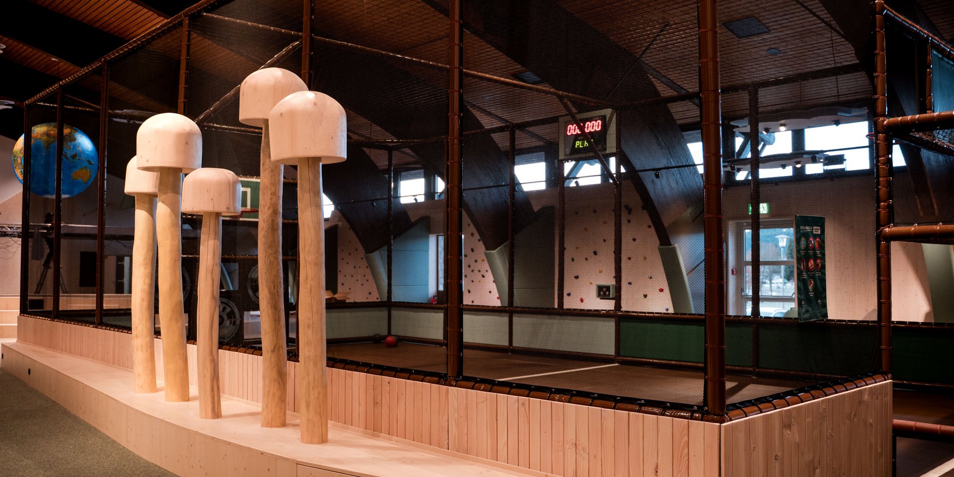 Große, stilisierte Holzpilze als Dekorationselemente in der fantasievollen Spielwelt des Hotels Vier Jahreszeiten.