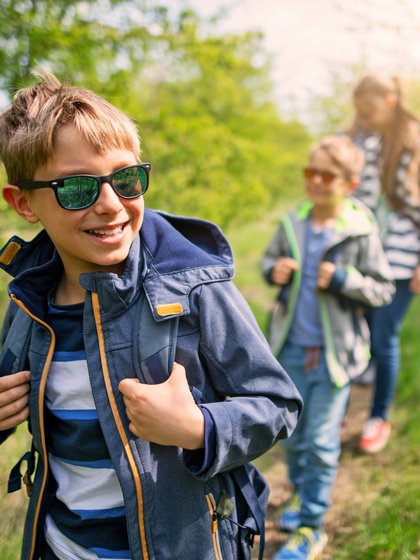 Eine Frau und zwei Jungen laufen durch den Wald