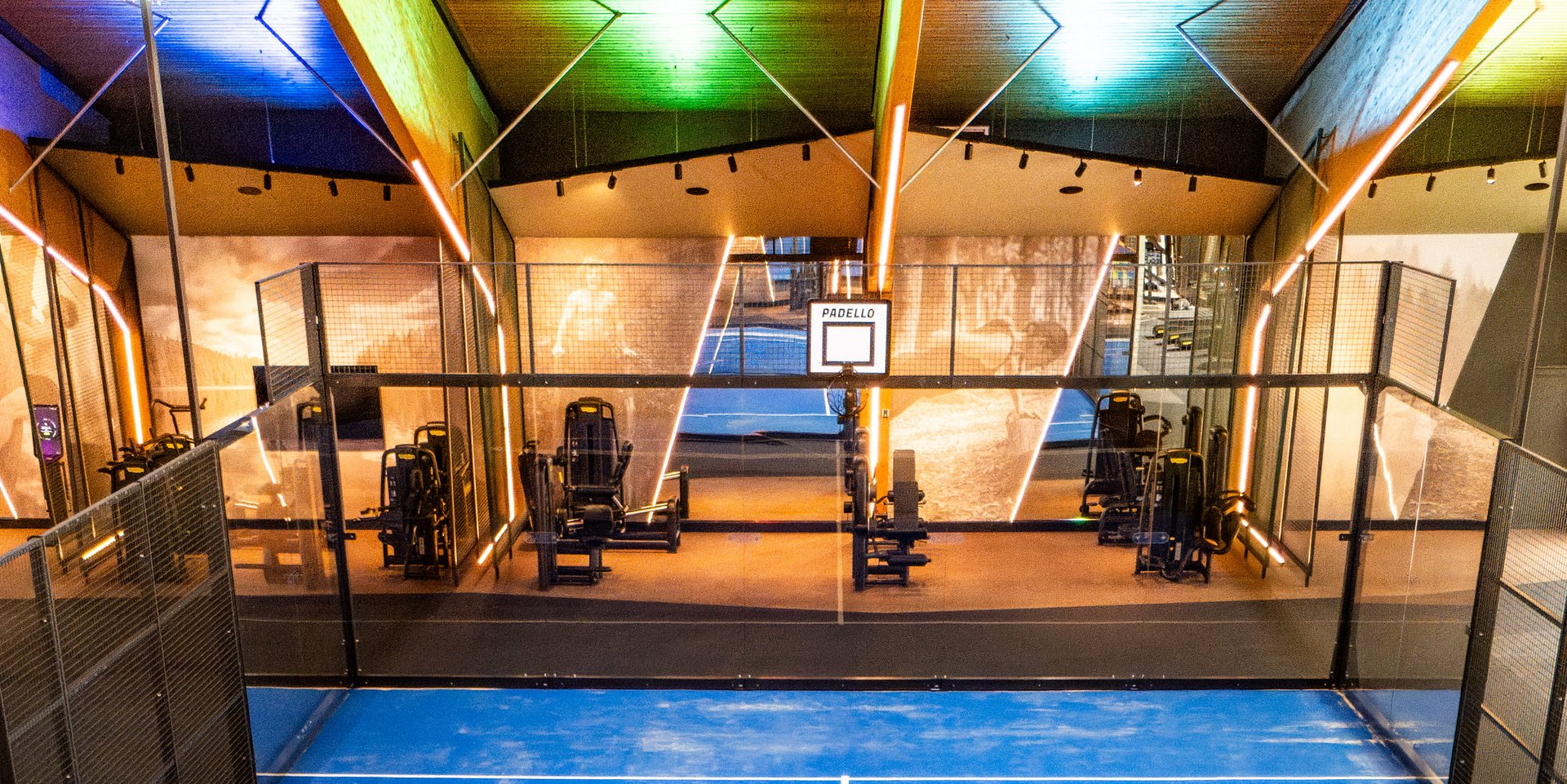 Vertikale Ansicht eines bespielten Padel-Courts unter der markanten Holzdecke des Hotels.