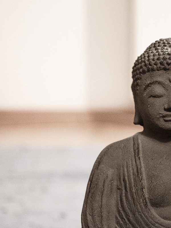 Meditierende Buddha-Figur in Steinoptik sorgt für eine friedliche Stimmung im Wellnessbereich des Hotels Vier Jahreszeiten im Schwarzwald.