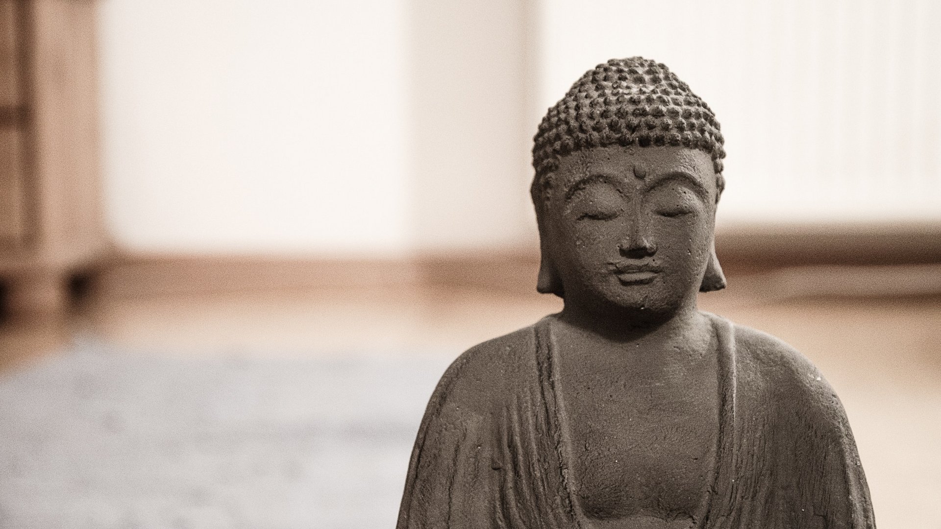 Meditierende Buddha-Figur in Steinoptik sorgt für eine friedliche Stimmung im Wellnessbereich des Hotels Vier Jahreszeiten im Schwarzwald.