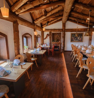 Traditionelles Restaurant-Ambiente mit massiven Deckenbalken und langen, eingedeckten Holztafeln im Schwarzwald.