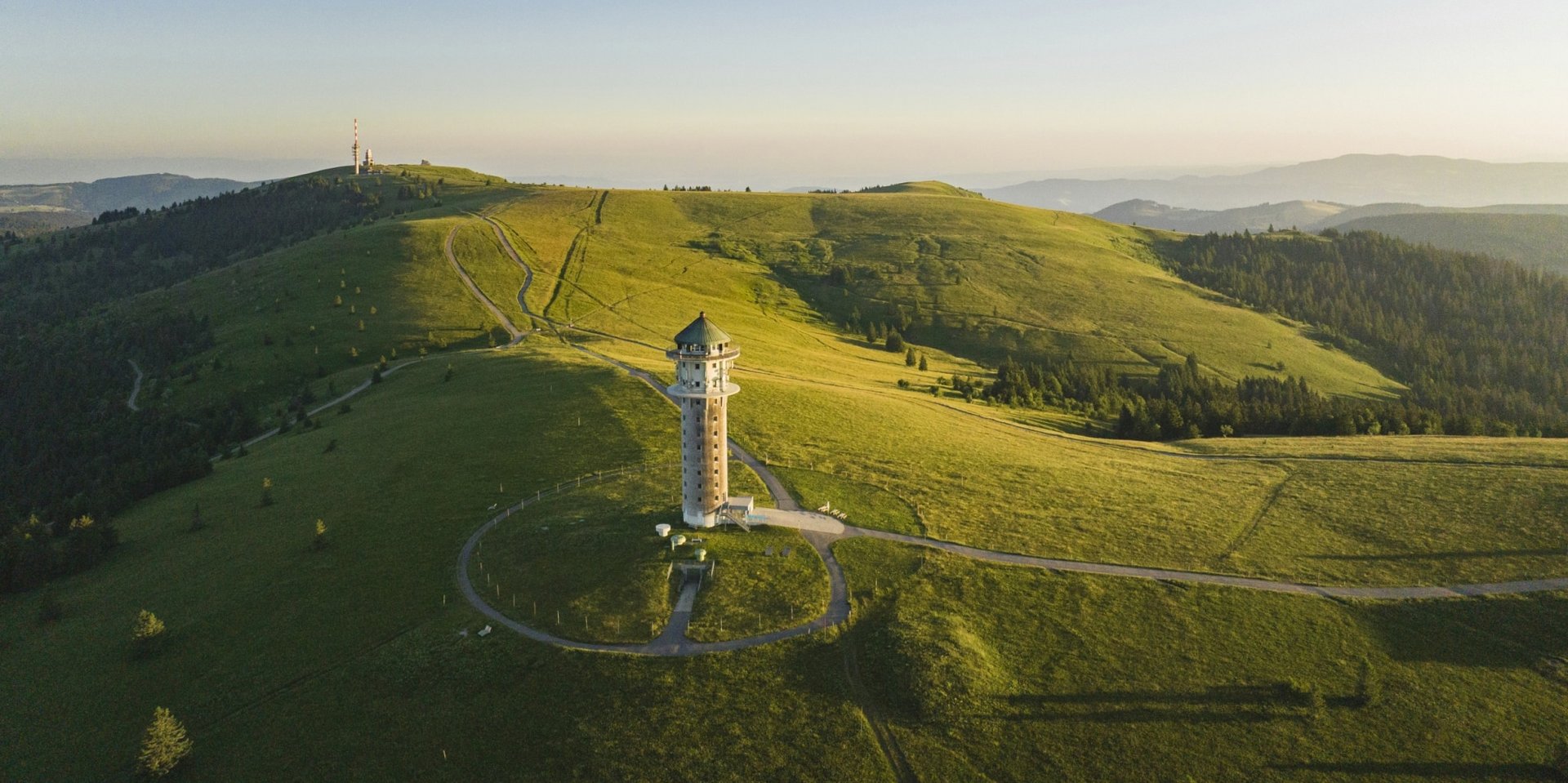 Luftaufnahme des Feldbergturms auf dem grünen Gipfel des höchsten Schwarzwaldberges im Sommer.