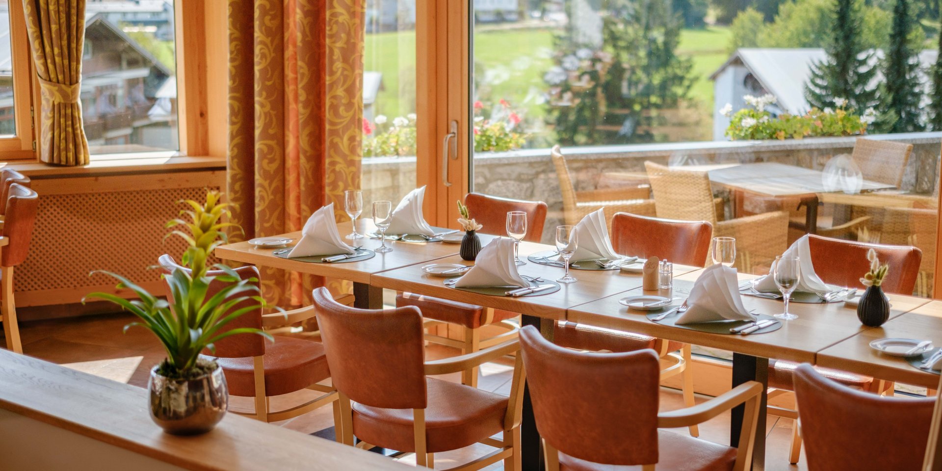 Restaurantbereich mit klassischer Bestuhlung und Blick auf die bewaldeten Hügel des Schwarzwalds.