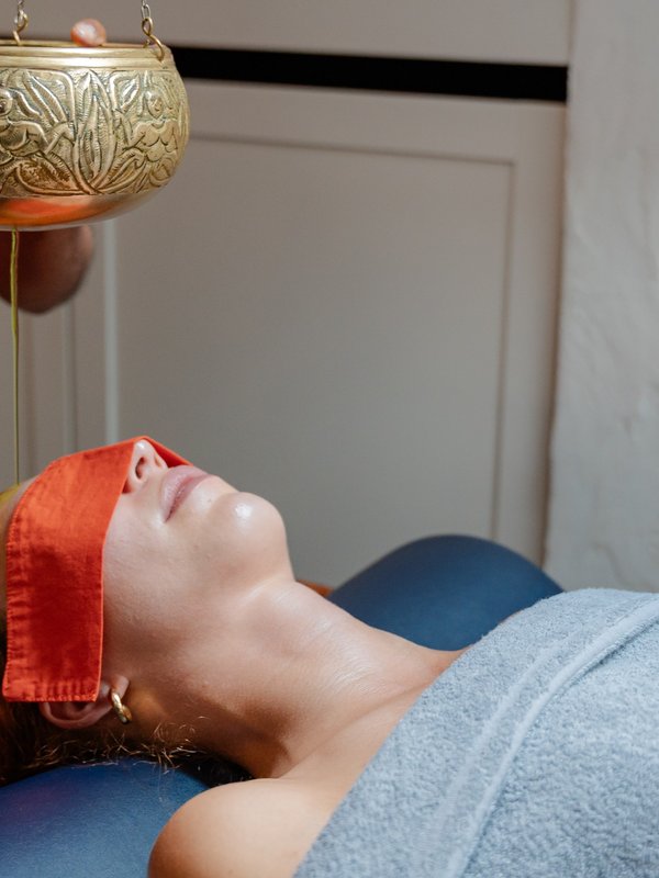 Seitliche Ansicht eines Ayurveda-Stirngusses zur tiefen Entspannung im Hotel Vier Jahreszeiten im Schwarzwald.