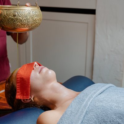 Seitliche Ansicht eines Ayurveda-Stirngusses zur tiefen Entspannung im Hotel Vier Jahreszeiten im Schwarzwald.