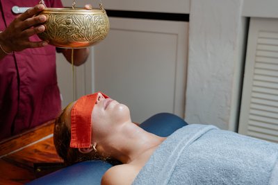 Seitliche Ansicht eines Ayurveda-Stirngusses zur tiefen Entspannung im Hotel Vier Jahreszeiten im Schwarzwald.