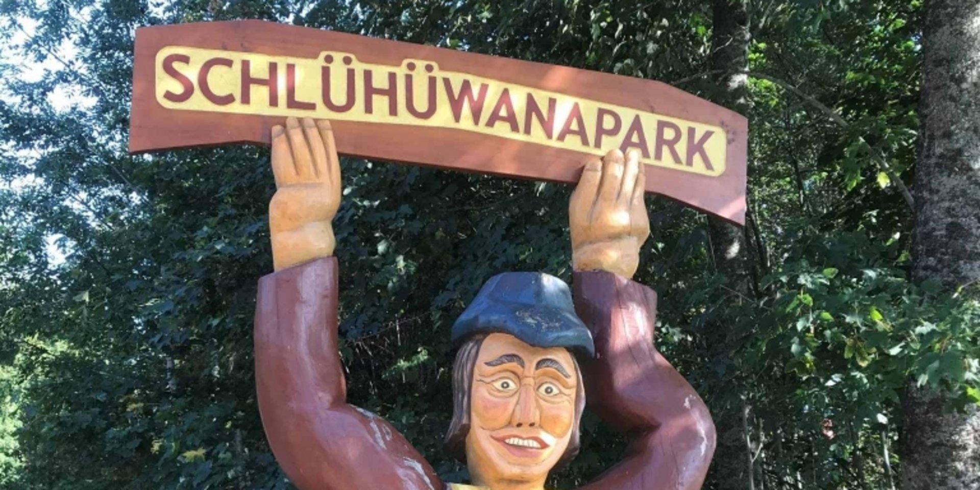 Eine lustige Holzfigur begrüßt die Besucher im Erlebnispark Schlüwana im Schwarzwald.