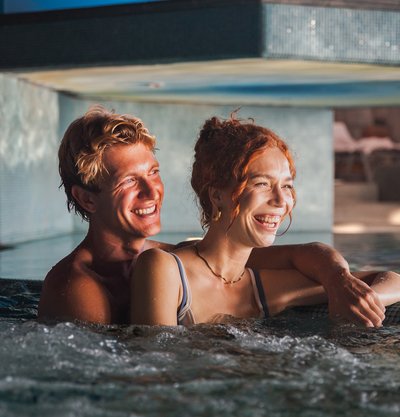 Ein Paar genießt entspannt die Massagedüsen im beheizten Whirlpool des Hotels Vier Jahreszeiten.