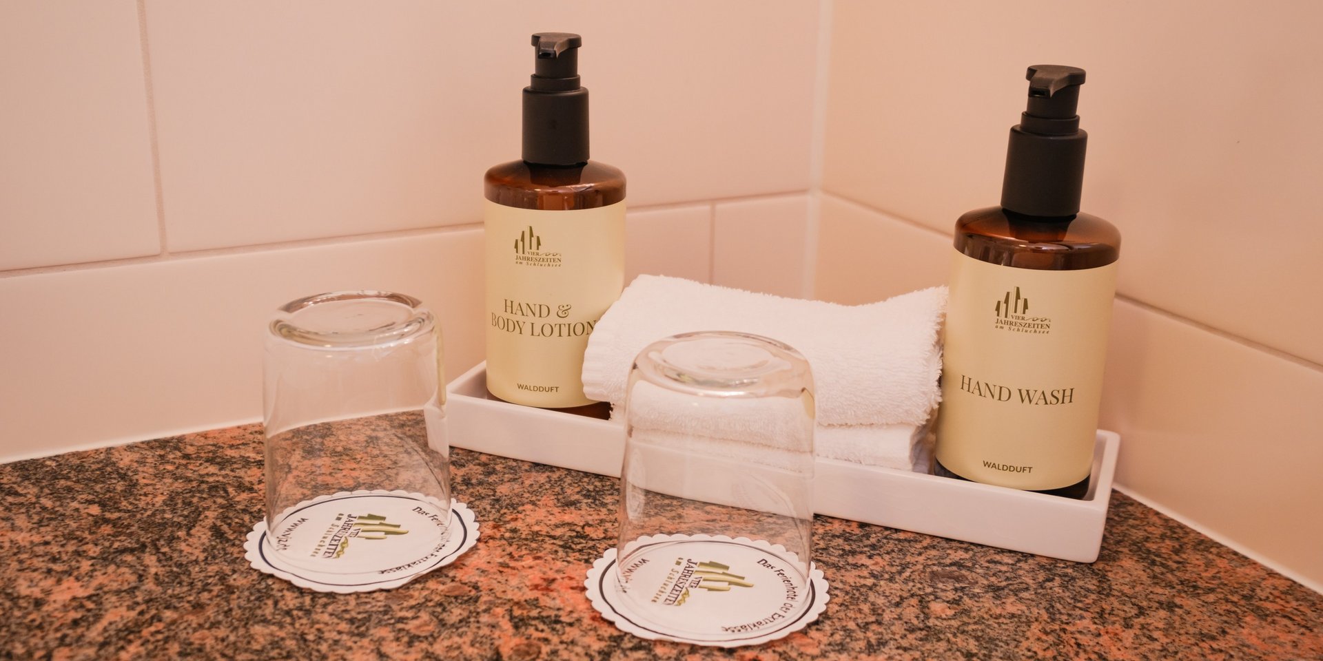 Hochwertige Pflegeprodukte und Gläser auf dem Waschtisch im Hotel Vier Jahreszeiten am Schluchsee.