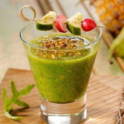 Ein Glas frisch zubereiteter grüner Smoothie mit Gemüsespieß als gesunder Snack im Hotel Vier Jahreszeiten.