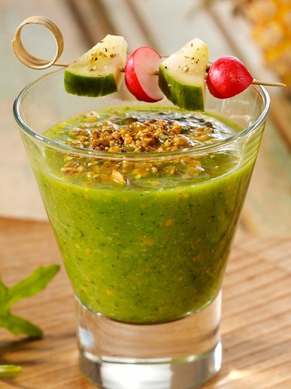 Ein Glas frisch zubereiteter grüner Smoothie mit Gemüsespieß als gesunder Snack im Hotel Vier Jahreszeiten.