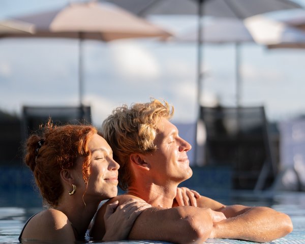 Ein entspanntes Paar am Beckenrand der Badelandschaft im Hotel Vier Jahreszeiten am Schluchsee.