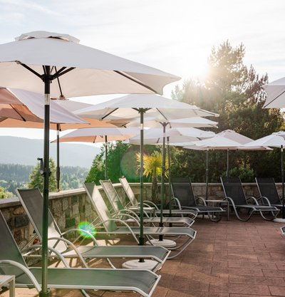 Entspannungsbereich im Freien mit Sonnenschirmen und Blick auf die Natur am Schluchsee.