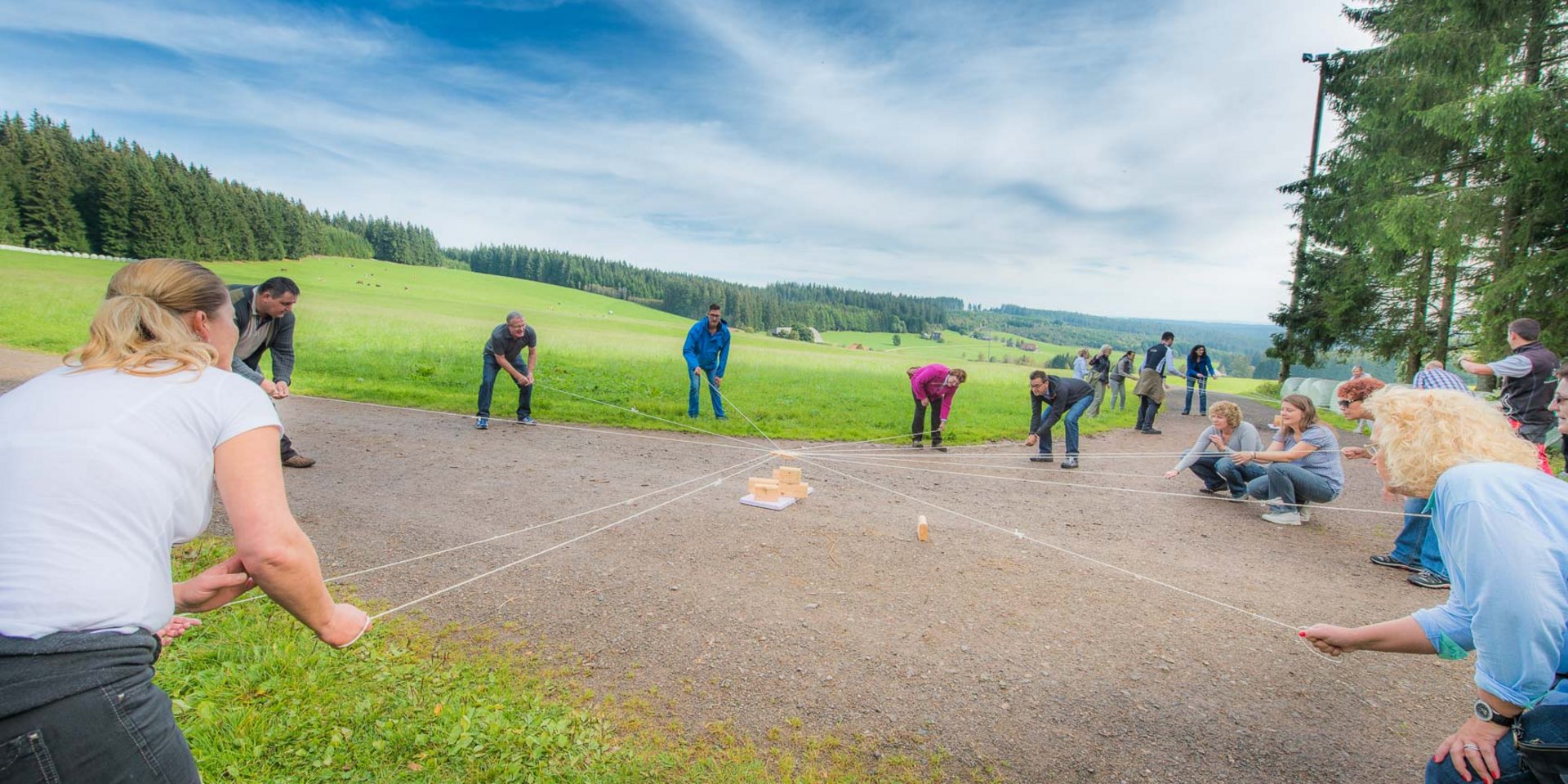 Menschen die an mehreren Seilen ziehen