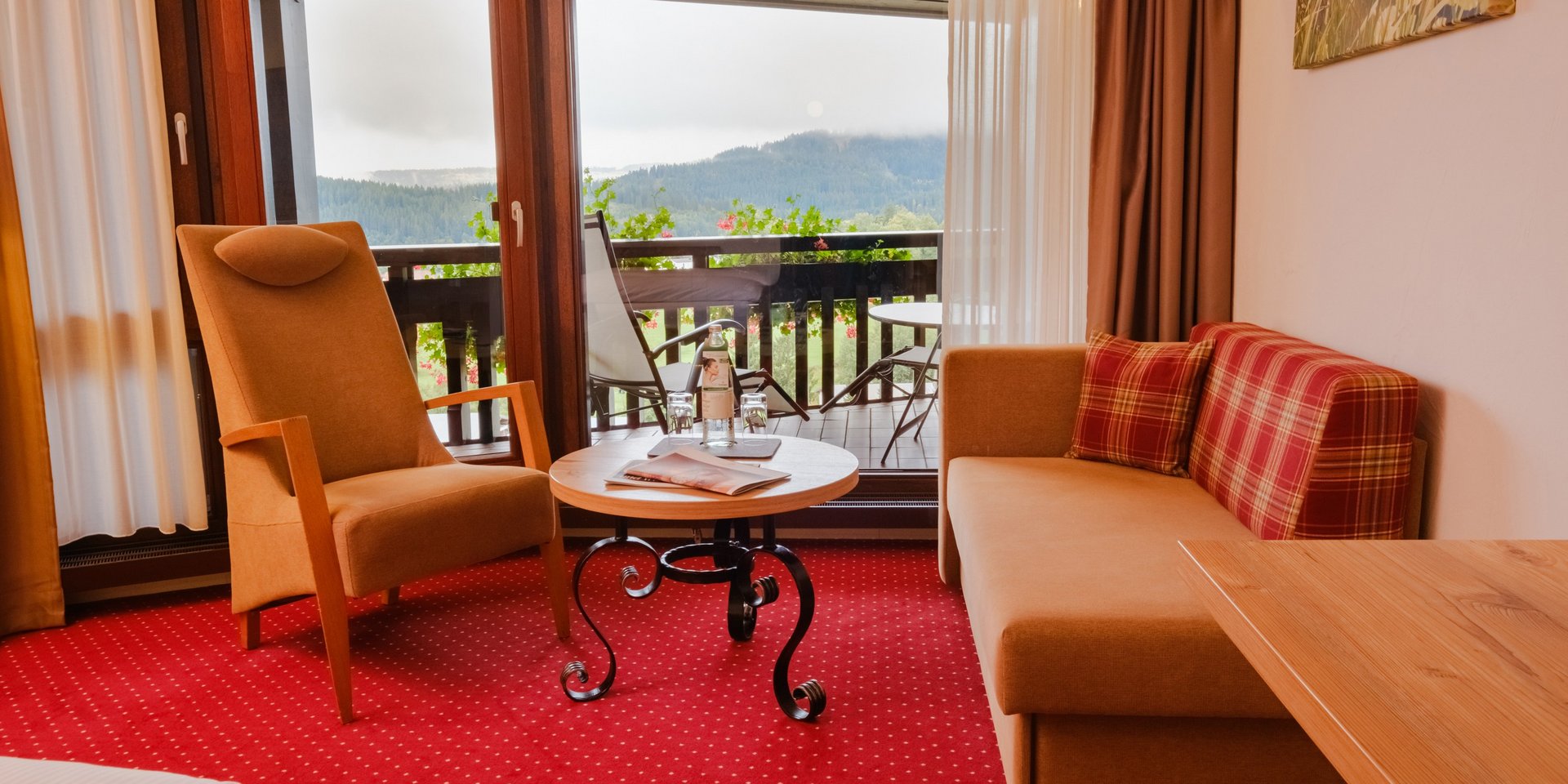 Gemütliche Sitzecke im Doppelzimmer Klassik Süd mit Sessel, Sofa und Balkonzugang im Hotel Vier Jahreszeiten am Schluchsee.