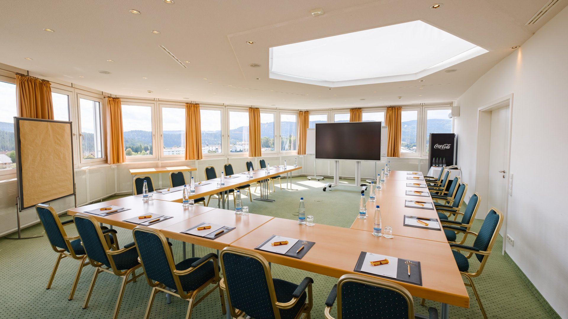 Moderner, lichtdurchfluteter Tagungsraum Schluchsee mit U-Form-Bestuhlung und großen Fensterfronten im Hotel Vier Jahreszeiten am Schluchsee.