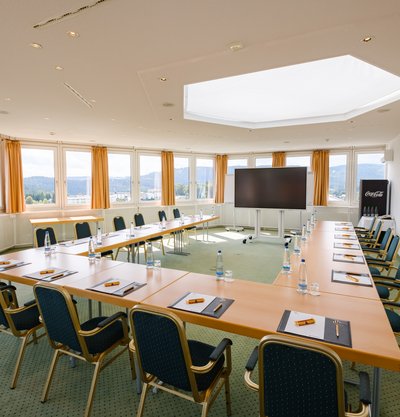 Moderner, lichtdurchfluteter Tagungsraum Schluchsee mit U-Form-Bestuhlung und großen Fensterfronten im Hotel Vier Jahreszeiten am Schluchsee.